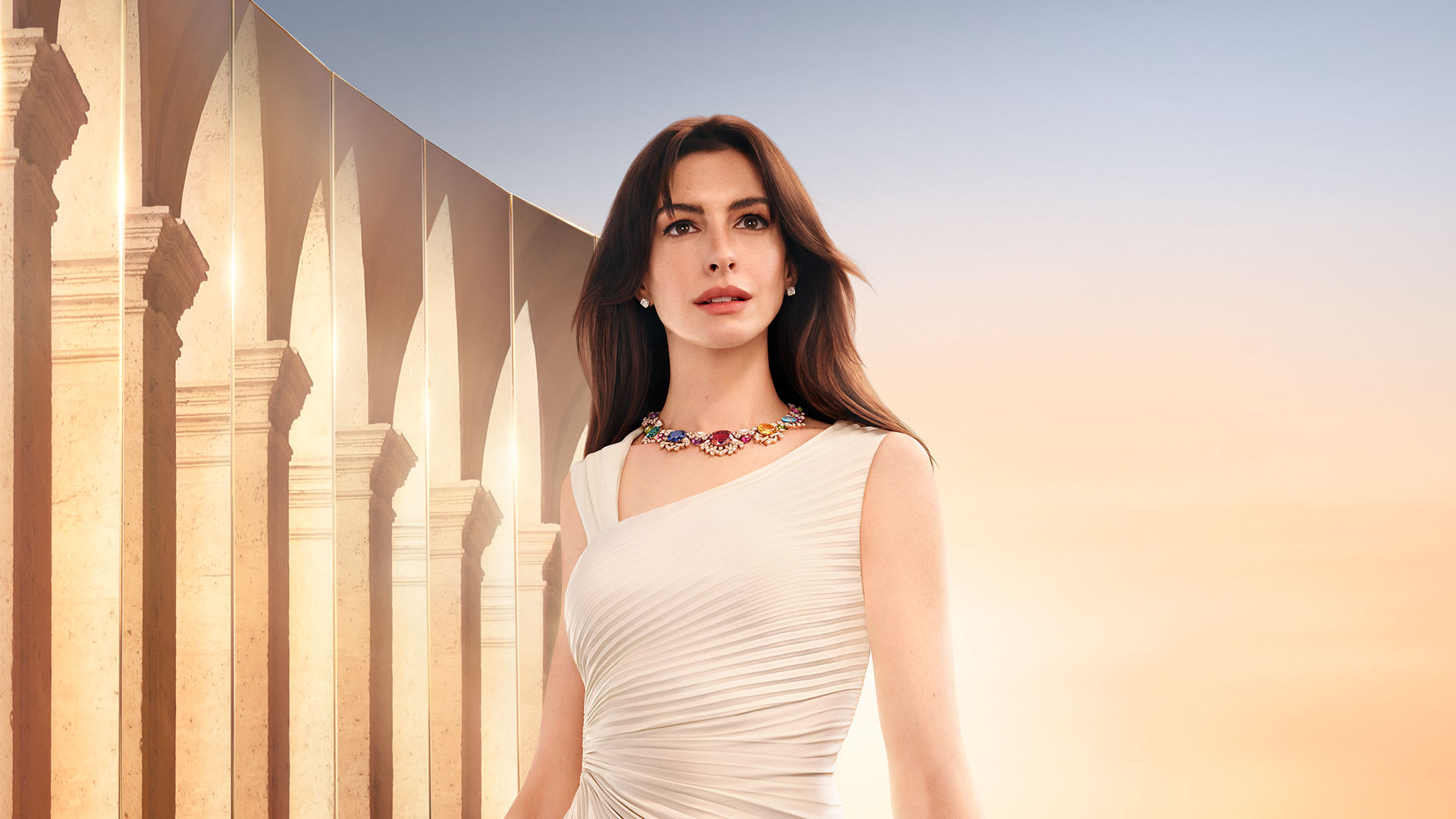 Anne Hathaway wearing a High Jewellery necklace for the Bvlgari Brand Campaign, a Roman monument in the back, the sky at dawn. 